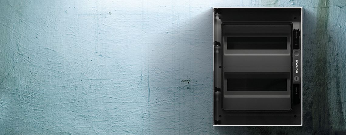 Scame industrial switchboard for wall installations. Detail of the closed switchboard, mounted on a rough wall, ideal for industrial and outdoor environments thanks to its watertight seal.