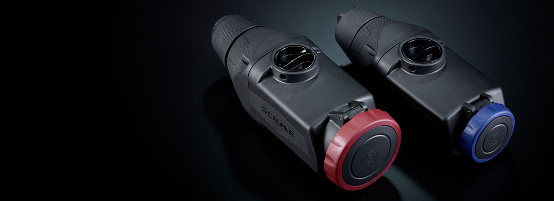 Scame mobile interlocked sockets for risk-classified areas. Detail of two black mobile sockets with colored caps, designed to ensure safety in industrial environments with risk of explosion or fire.